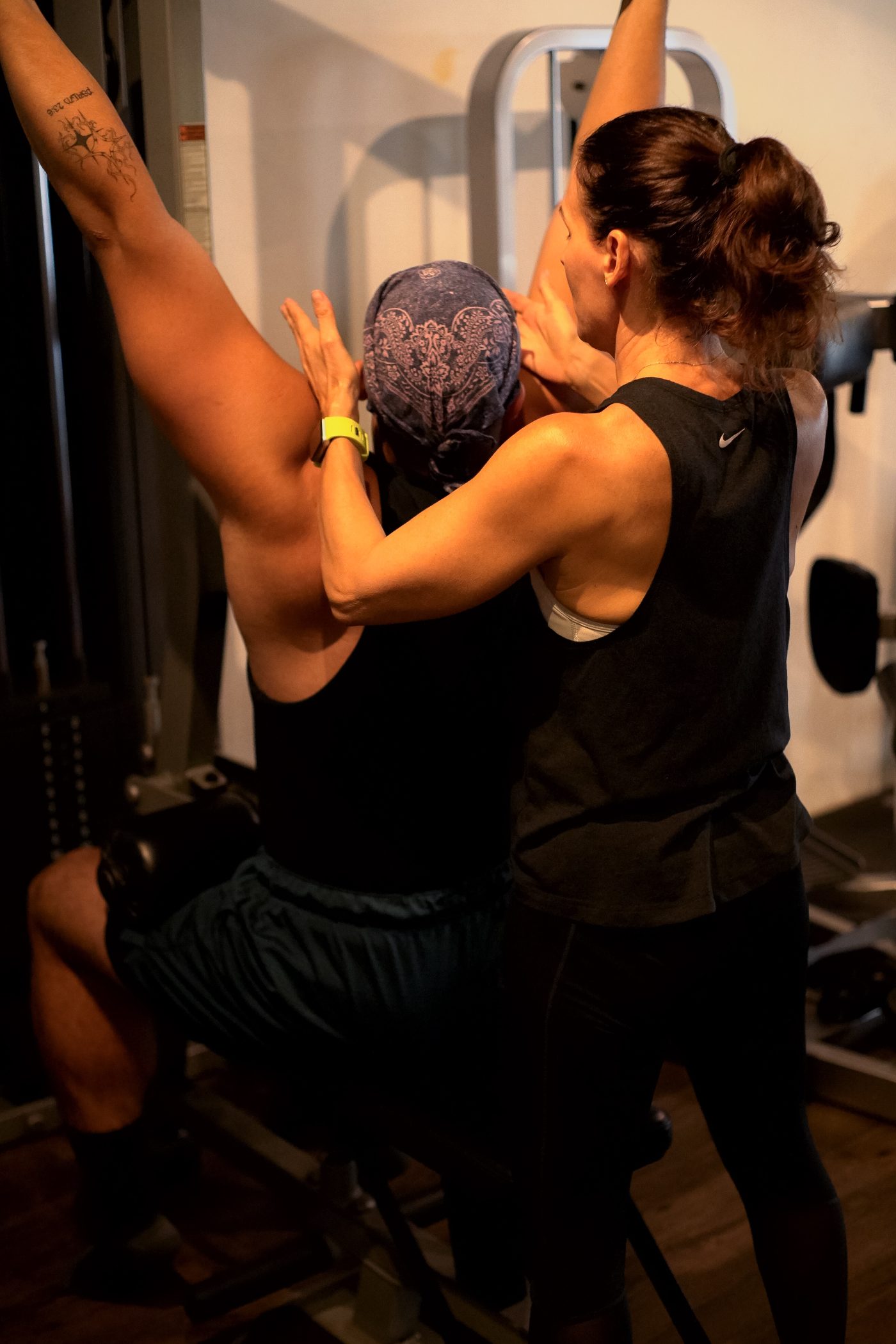 A Body for Life coach correcting a client's form during a 1:1 session
