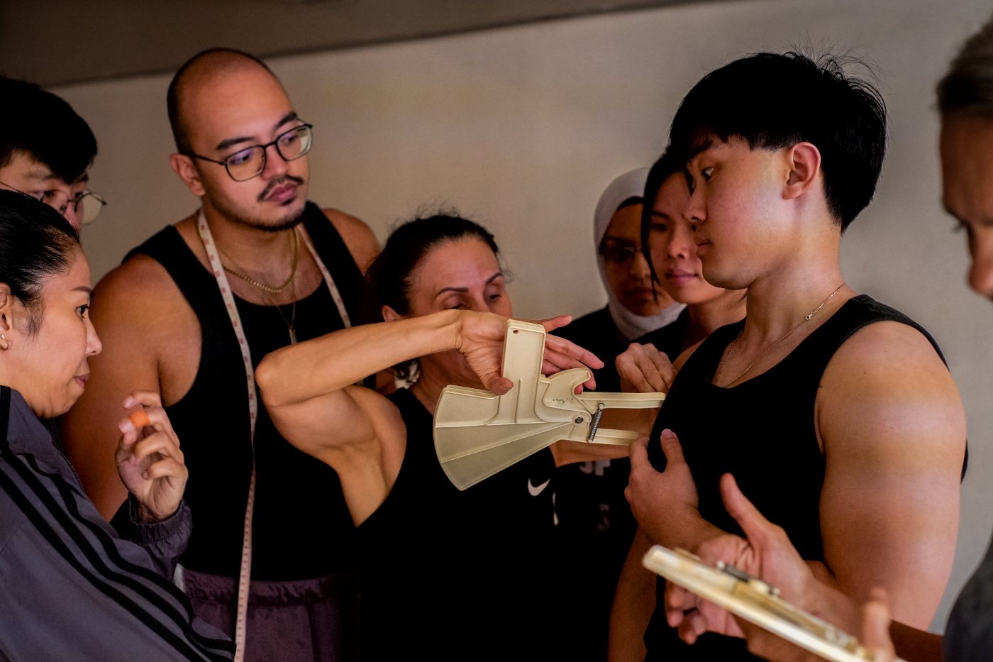 Simone demonstrating a skinfold caliper measurement to a group of trainee coaches